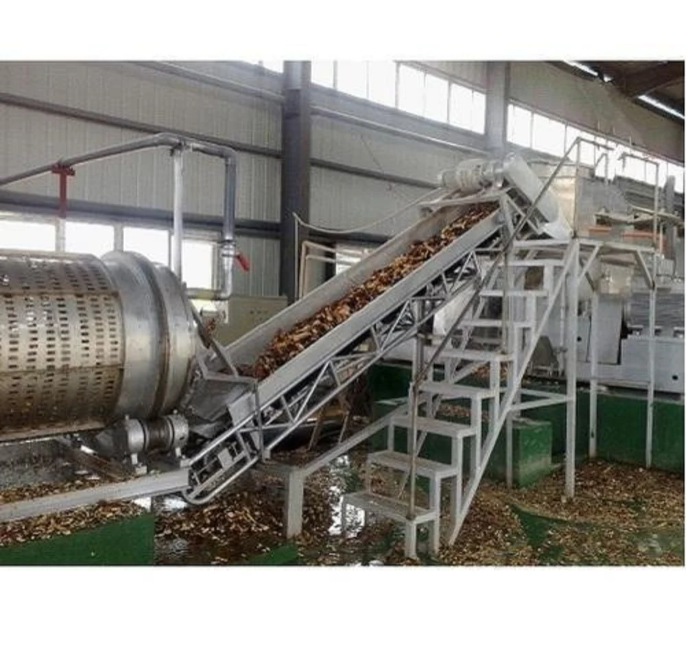 Industrial wood chipper and inclined conveyor system for bulk material processing.